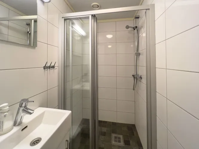 A bathroom with shower and sink.