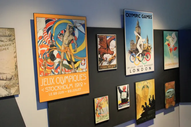 Wanddisplay mit mehreren Vintage-Postern zu Olympischen Spielen, darunter Stockholm 1912 und London 1948..